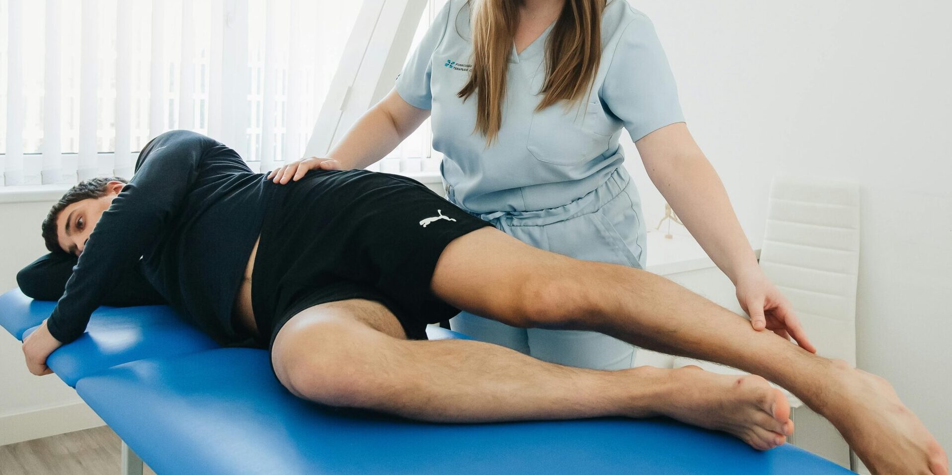 A physiotherapist assists a patient in a rehabilitation session at a Vilnius clinic.